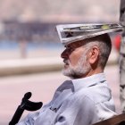 Un hombre se cubre con un periódico para paliar el calor.