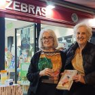 Marie Córdoba y María Jesús Orbegozo a las puertas de la librería Zebras con un ejemplar de \'¡Que viva Frida1\'