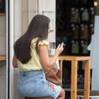 Una persona fumando en la terraza de un bar.