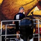 Moxaico durante la realización de su mural.