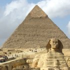 La Gran Esfinge y las pirámides de Guiza rodeada de turistas.