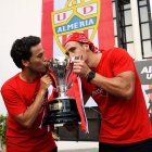 Rubi y Fernándo besan la copa de campeones de Segunda División.