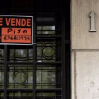 Vista de un cartel de ‘Se vende piso’ en un portal de un edificio.