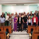 Foto de familia de los alumnos graduados junto a los miembros de la mesa inaugural.