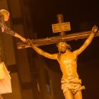 Una mujer toca la imagen del Cristo del Perdón instantes después de su salida de la iglesia de San Ildefonso.