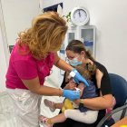 Una menor se vacuna este lunes en el centro de salud Mediterráneo.