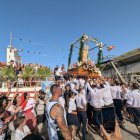 Los costaleros alzan a la virgen para embarcarla.