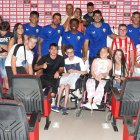 Jugadores y niños juntos en la sala de prensa del club.
