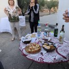 Una de las mesas con los dulces tradicionales y vecinas del lugar.