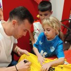 Fernando firmando la camiseta a Martina en el aniversario de la Peña Milhojas.