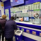 Varias personas compran décimos de Lotería en una administración de Loterías.