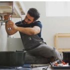 Un fontanero trabajando en una vivienda.