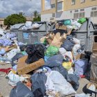 Contenedores repletos y basura en la vía.