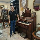 El anticuario Serafín Gutiérrez, de Antique, junto a un armonio (una especie de piano) de Boston de la época del viejo oeste americano.