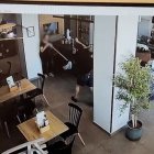 La empleada del establecimiento utiliza la fregona para mantener la distancia con el asaltante