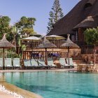 Parte del Club Cocodrilo con la piscina en primer término y la cabaña africana al fondo.