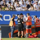 El jugador de pie pidiendo volver al campo pero no se lo permitieron.