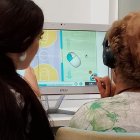 Fisioterapeuta acompañando a una paciente durante una sesión de rehabilitación motora.