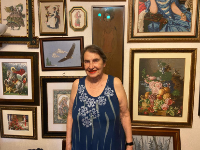 Kitty Vizcaíno posa a sus 93 años frente a su colección de punto de cruz, todo elaboración propia.