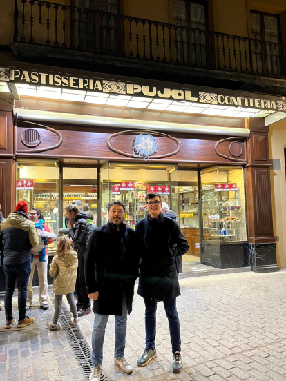 Padre e hijo frente a una pastelería con su apellido.