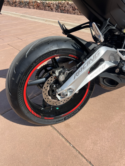 Basculante de aluminio con bieletas progresivas y neumáticos Michelin Power GP para máximo agarre en pista y carretera.