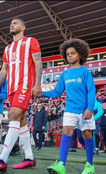 Luis Suárez saliendo al campo con Neil M'Bami Sánchez en un día muy feliz.