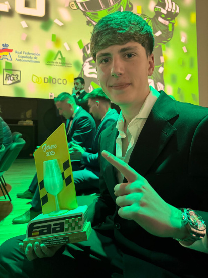 Mostrando el trofeo recibido.