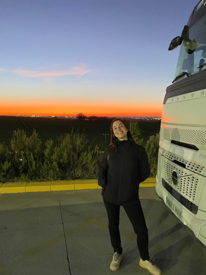 Luz García sonríe ante la cámara junto a su camión y frente a un atardecer memorable.
