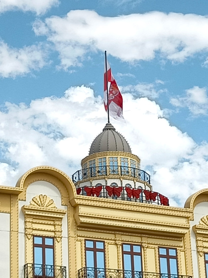 Detalle de la reproducción de la cúpula del Edificio de las Mariposas en la portada del Ferial, rematada con la bandera de Almería.