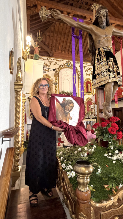 Emilia Resina Portaz muestra la pintura donada junto al Cristo del Bosque.