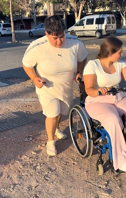 Minerva ayudando a su prima a subir a una acera en mal estado.
