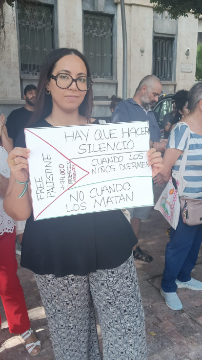 Una chica sostiene un cartel a favor del cese de la guerra.
