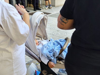 Un carrito con un bebé durante la concentración de las 32 familias.